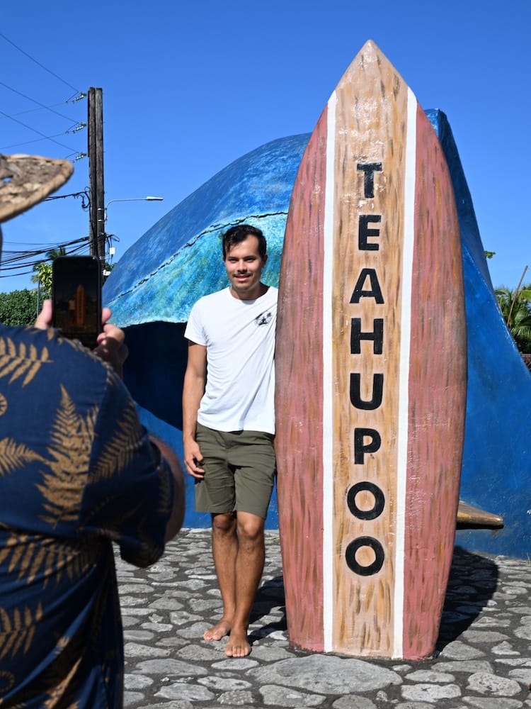 Posing for Photos with a Surf Board Statue in Teahupoo Village