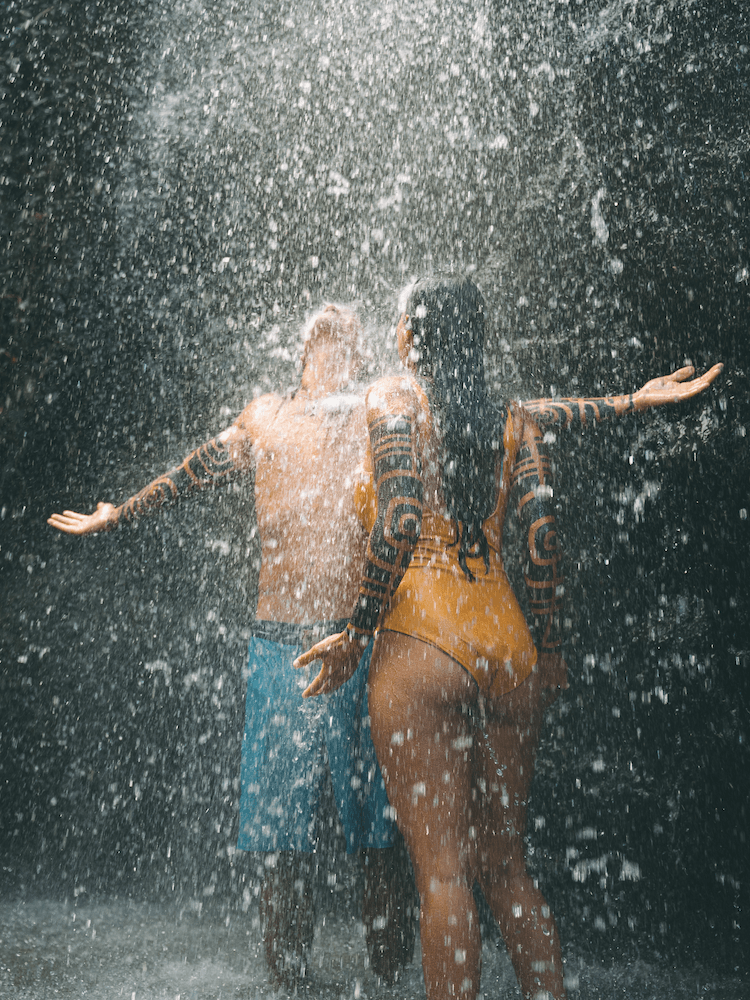 Unique Tahiti - Tahitian Island Tours - Couple Playing Under a Waterfall