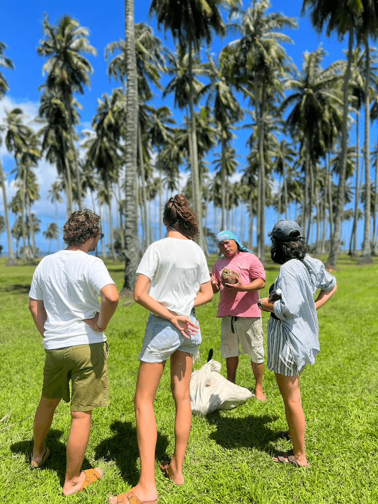 West Cost Full Day Tour of Tahiti - Guide with Coconuts in Front of Palm Trees