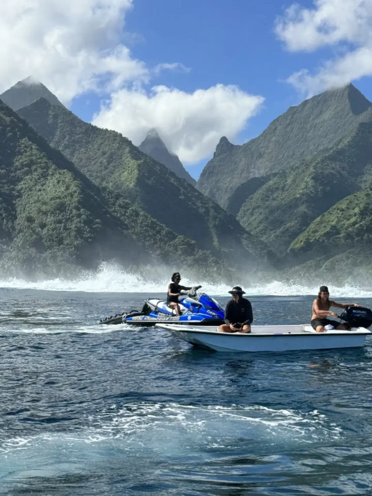 Tahiti tourists riding boats and jet skis in the ocean overlooking the mountains